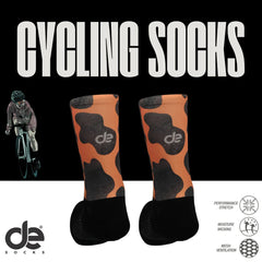 Cow ποδηλατικές κάλτσες-αναπνέουσες με πορτοκαλί-μαύρο σχέδιο και λογότυπο de. Με διαπνοή, stretch και απορρόφηση υγρασίας για ποδηλάτες.